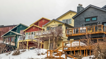 Fototapeta na wymiar Panorama Facade of mountain homes with horizontal siding balconies and outdoor stairs