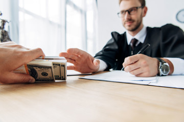 top view of man giving cash to judge sitting in office