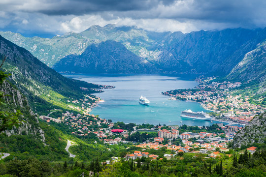 Montenegro, Bay of kotor city with many houses, waterside and harbor with two cruise ships inside pretty mountains nature landscape