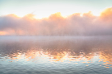 Misty calm lake reflection in the sunrise