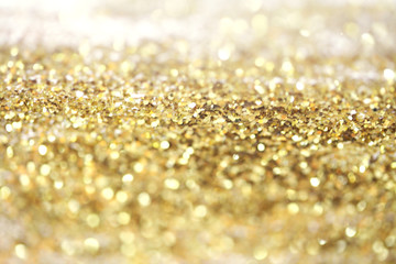 Gold (bronze) glitter shine dots confetti. Abstract light sparkle defocus backgound.