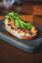 Burger with mushrooms, fried onions and cheese on rustic background