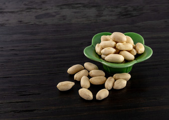 group of raw peanuts in continers on wood backgorund
