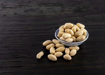 group of raw peanuts in continers on wood backgorund