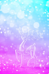 Silver glitter Christmas deer in trendy neon colors. Rainbow gradient background with lights bokeh, copy space. Greeting card for new year party. Festive holiday concept. Banner