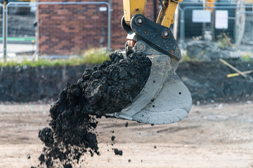 A digger and dump truck move dirt to make room for the foundations of the new Waverley School in Sheffield, South Yorkshire, UK