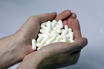 man holds many pills in his hands
