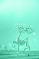 Silver glitter Christmas deer on neon blue background with lights bokeh, copy space. Greeting card for new year party. Festive holiday concept. Banner