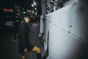 Portrait of asian woman hair dreadlock smoking night scene in the city,Thailand people pose for take a photo,feeling lonely,sad woman concept