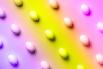 Food concept with white chicken eggs in trendy neon colors. Rainbow gradient background. Top view. Creative pattern in minimal style. Flat lay.