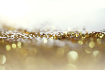 Gold (bronze) glitter shine dots confetti. Abstract light blink sparkle defocus backgound.
