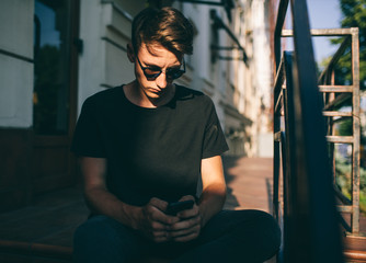 Young man using his smartphone. chatting in social networks with friends. Shopping online.