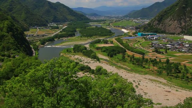 Tilt up of Chikuma River in mountain landscape, Japan