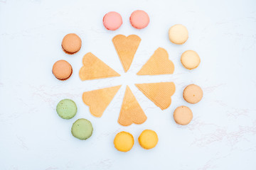 Fun flat lay composition of the colorful and sweet tasting small French cake macaron or macaroon combined with cookies