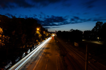 Fototapeta na wymiar Nightscape car moving light trail long exposure photography in a city landscape during the night time with cloud movement
