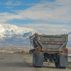 Square Road and industrial vehicle with valley and snow capped mountain background