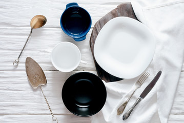 Empty plates with a copy space for food on a white aged wooden kicthen table background.