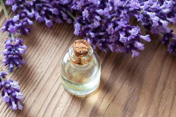 Obraz na płótnie Canvas A bottle of lavender essential oil with fresh plant