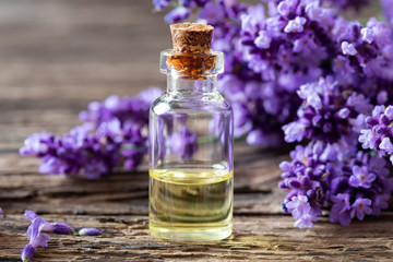 Obraz na płótnie Canvas A bottle of lavender essential oil with lavender tiwgs