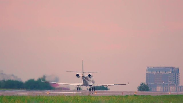 Business jet taking off at sunset. Back view