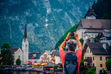 Obraz na płótnie Canvas Hallstatt, Austria: Tourist take a photo of famous church and village