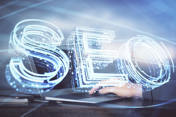 Double exposure of seo icon with man working on computer on background. Concept of search engine optimization.