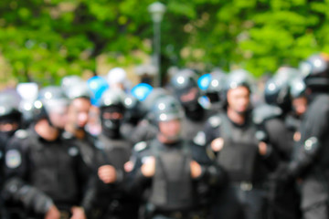 Blurred image of police at a mass event. A detachment of police in helmets protects the order at the rally. Policemen at a demonstration on a street