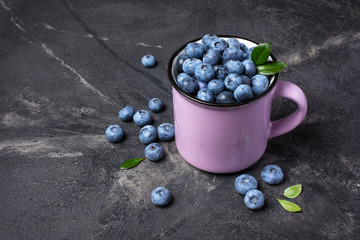 Fresh blueberry berries in purple mug