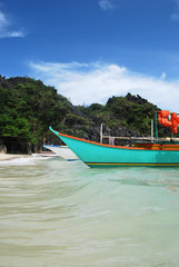Plakat Natural landscape: tropical sand beach with forest, crystal clear sea and a boat on the foreground.