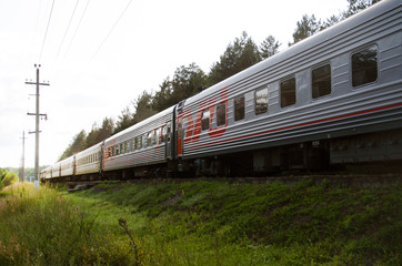 Fototapeta premium Red-gray passenger long-distance train close-up. Russian Railways.