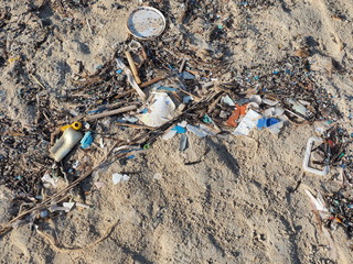 Environmental pollution. Sand beaches polluted with pieces of plastic waste. Micro plastics debris...