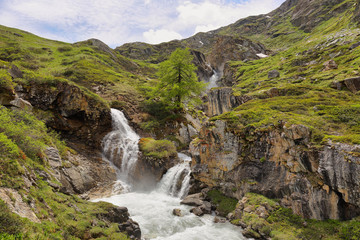 Fototapeta na wymiar Beautiful waterfall in the way to Rifugio Benevolo, Val d'Aosta, Italy
