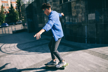 Hipster male rides on skateboard. boy rides longboard outside