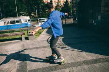 Hipster male rides on skateboard. boy rides longboard outside