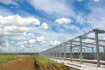 Fototapeta na wymiar Metal construction on blue sky background. The construction of prefabricated buildings and structures for agriculture.