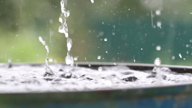 Raindrops falling on water surface. Heavy rain, splashes