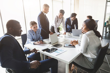 A team of young businessmen working and communicating together in an office. Corporate businessteam and manager in a meeting