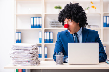 Young clown businessman working in the office