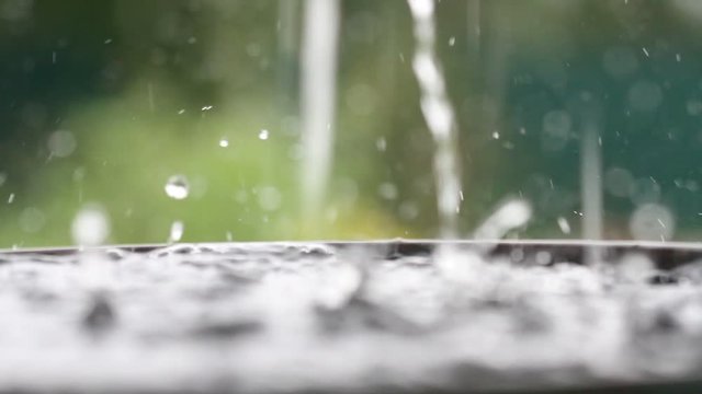 Raindrops falling on water surface. Heavy rain, splashes