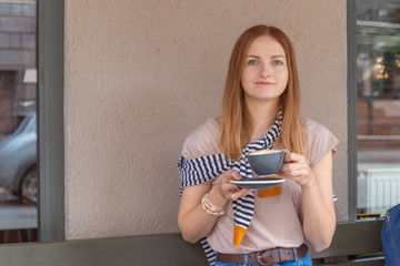 Young woman having a breakfast with coffee outdoors in a cafe