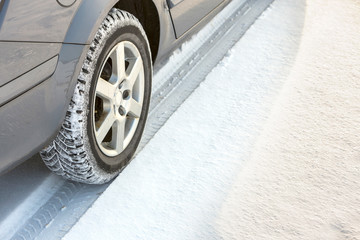 Close-up of car wheels rubber tire in deep snow. Transportation and safety concept.