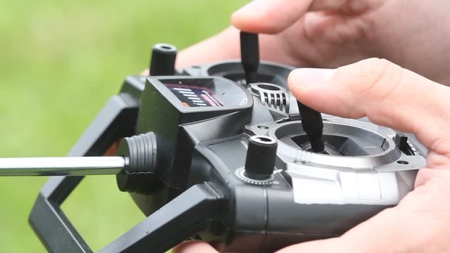 Piloting Radio controlled helicopter with remote control. Hands holding a transmitter