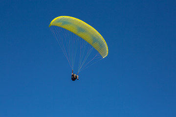 paraglider flying in the blue sky among the white clouds. Paragliding