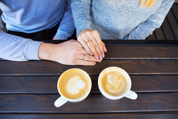 young loving couple sitting in cafe, two cups of cappuccino, red plaid