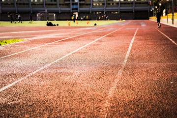 Close-up treadmills of a stadium, building and stands. Children train on the football field, the athlete runs on a treadmill.