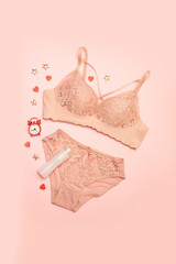Set of glamorous stylish sexy lace lingerie with women's accessories on a pink background