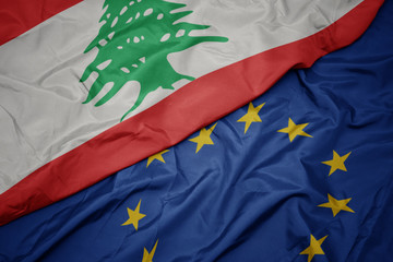 waving colorful flag of european union and flag of lebanon.