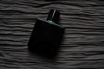 Dark blue glass perfume bottle isolated on textured brown cloth