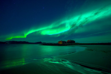 Cabin at the beach under northern light