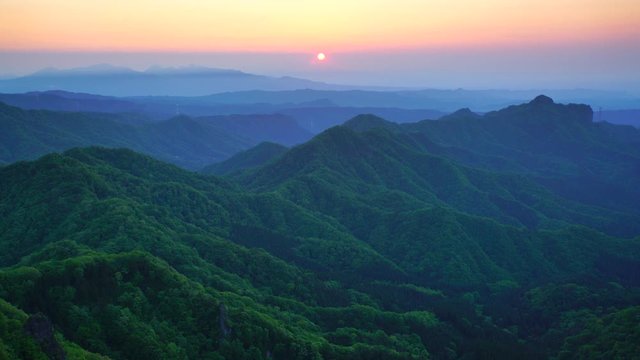Zoom out view of mountain range at sunrise